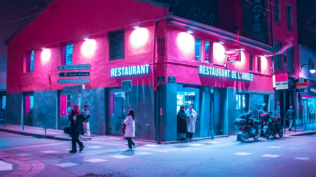 A group of people walking across a street at night