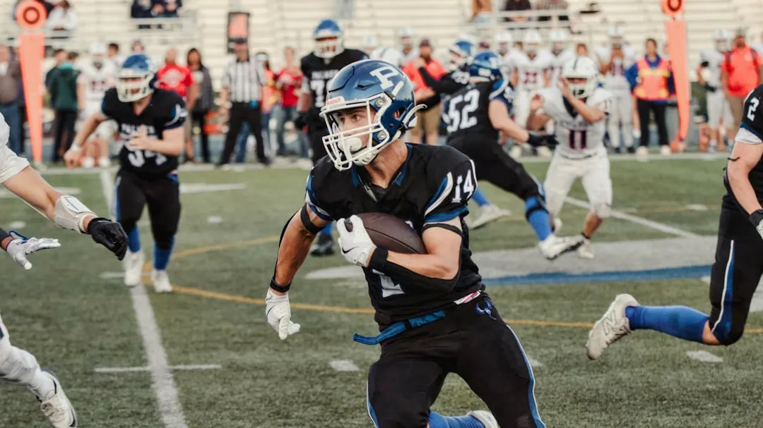 Football player running with the ball during a game.