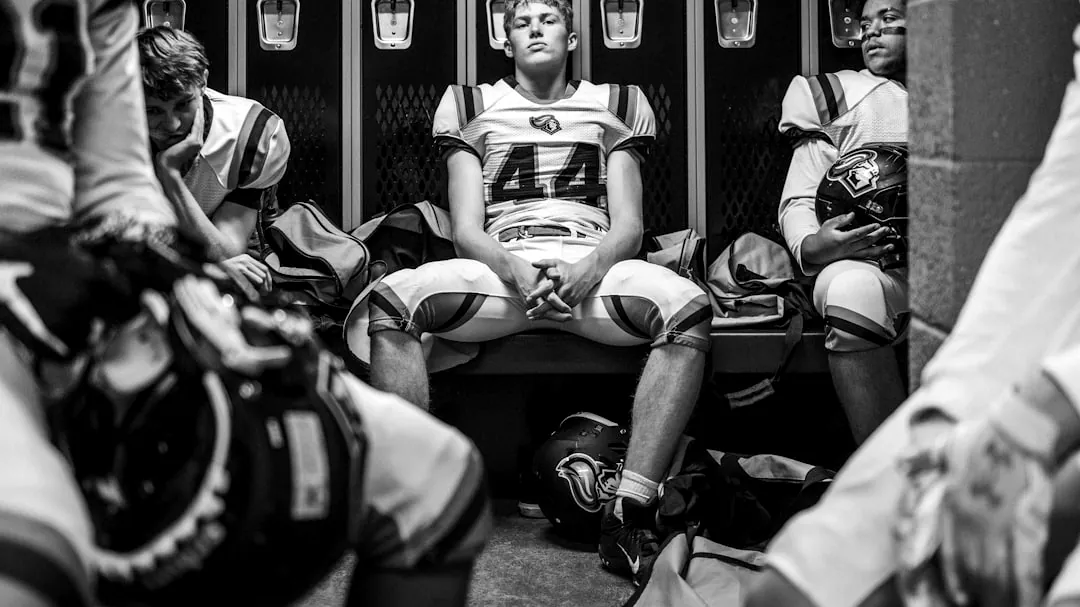 Football players sitting in a locker room