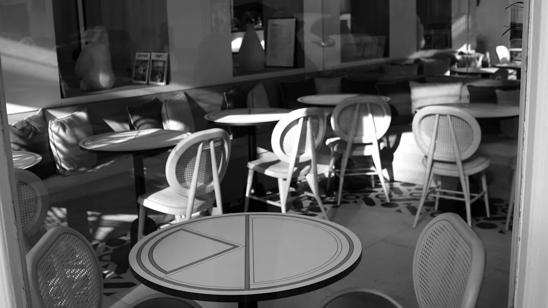 a black and white photo of tables and chairs