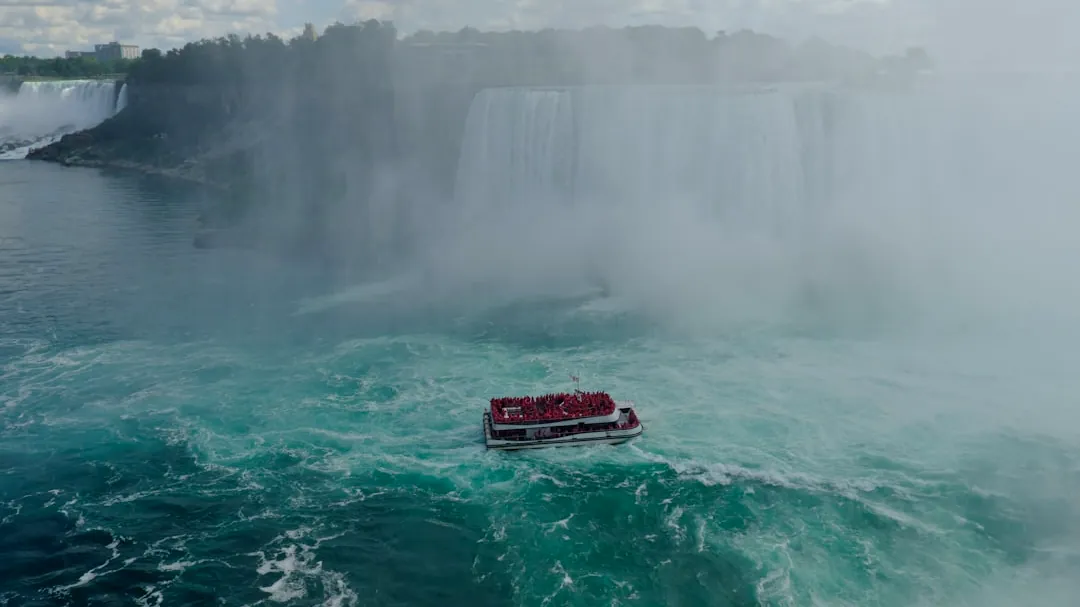 a boat in a body of water near a waterfall