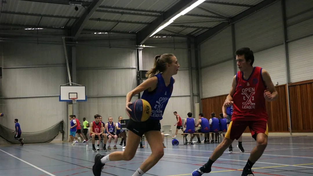 a group of young people playing a game of basketball