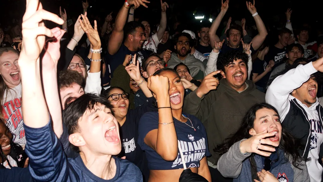a large group of people are cheering at a concert