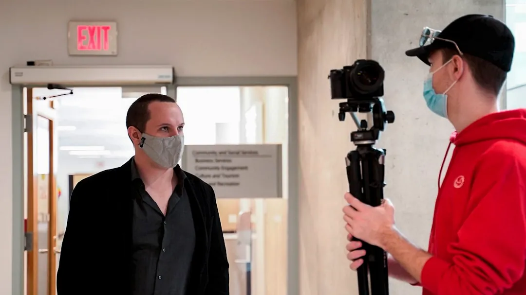 a man wearing a face mask while filming another man