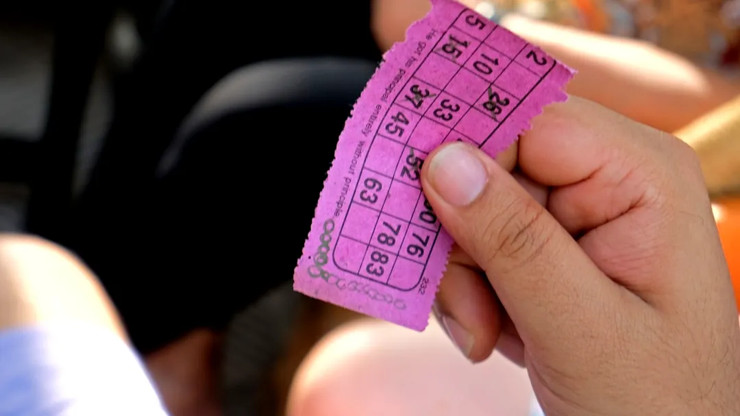 a person holding a pink ticket in their hand