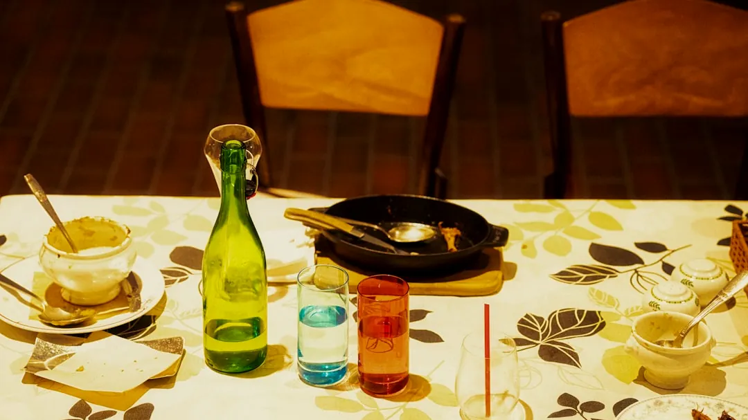 a table topped with a bottle of wine next to a plate of food