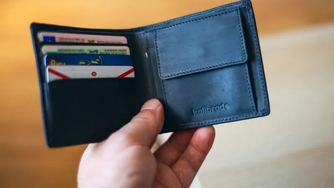 black leather bifold wallet on persons hand