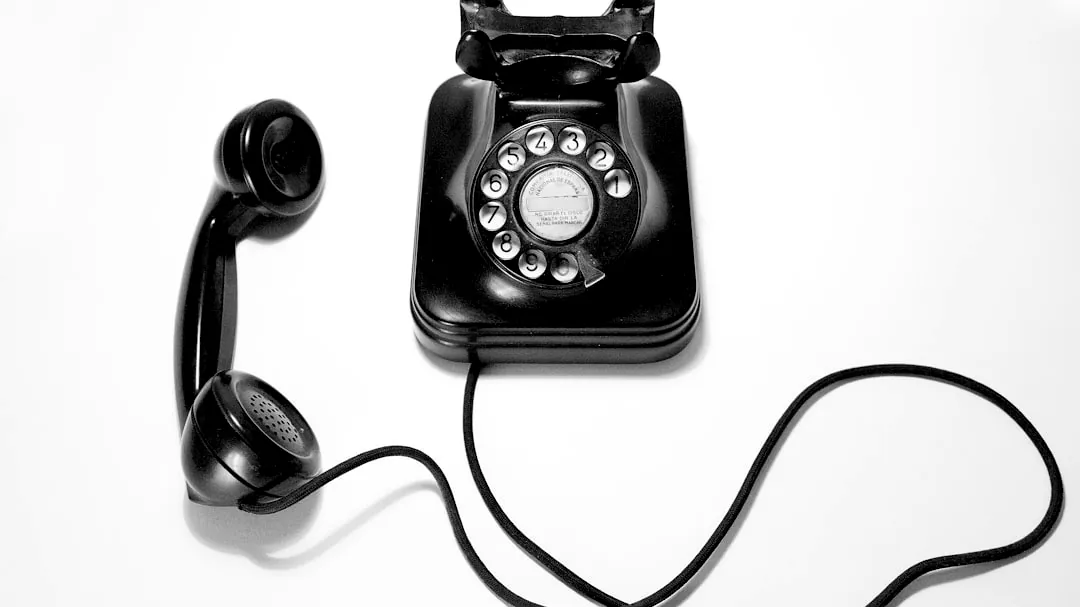 black rotary dial phone on white surface
