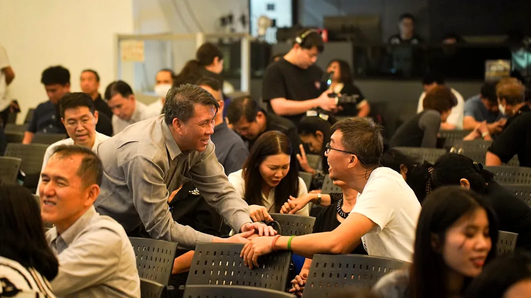 People gathered in a room, some interacting.