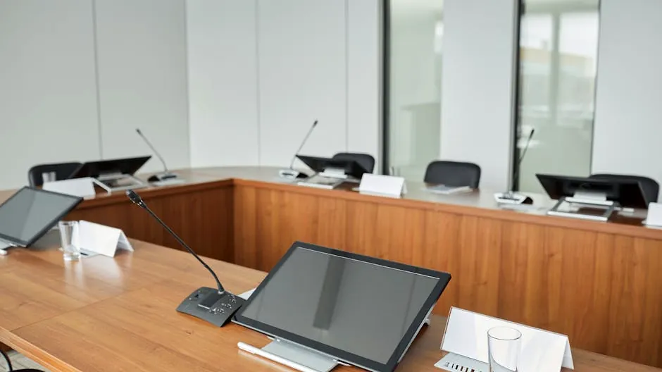 Spacious conference room equipped with modern technology and microphones for meetings.