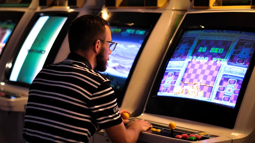 man in black and white striped shirt playing arcade game