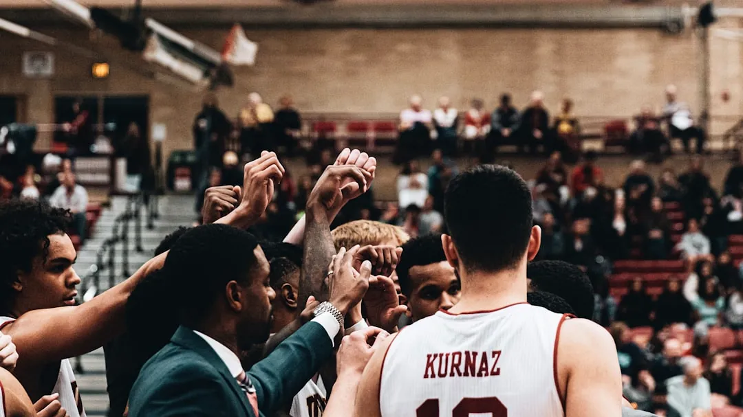 man in white tank top standing in front of people during daytime